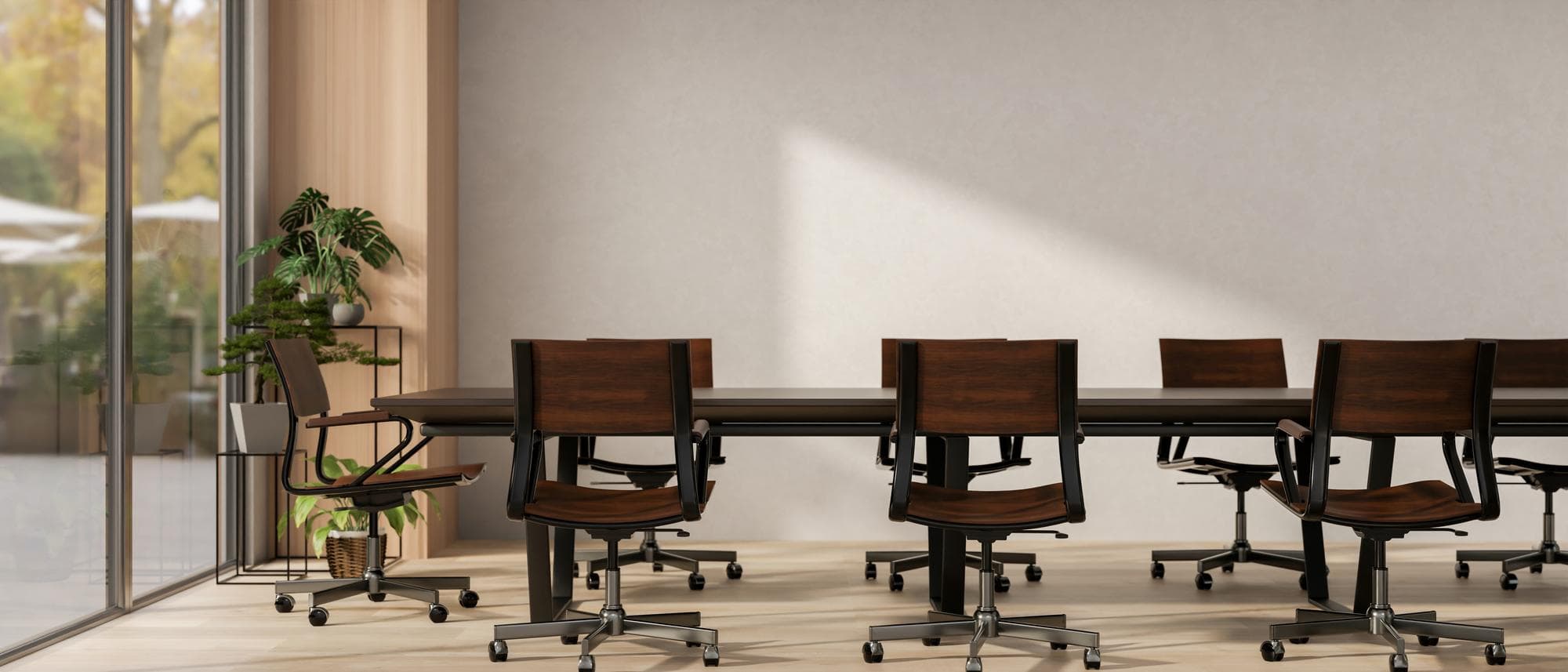Two empty boardroom chairs facing each other across a wood table, soft window light, an open laptop on the table between them